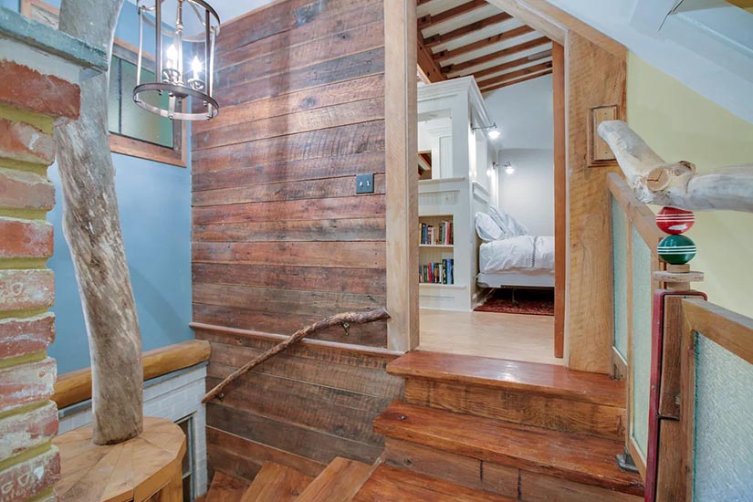 More of that gorgeous old wood at the top of the stairs, and you can peek into the bedroom.